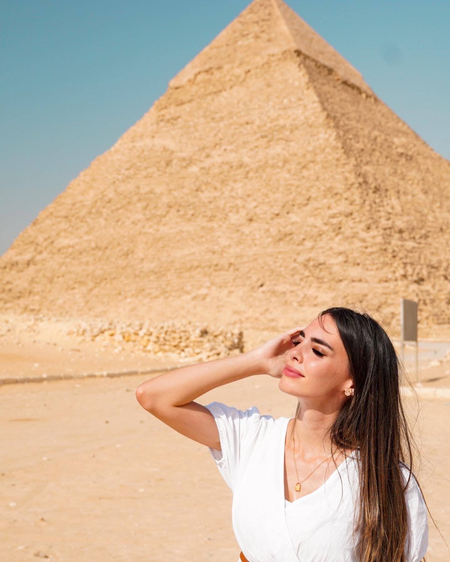 Na foto Violet (mulher) está em frente a pirâmides no Egito 