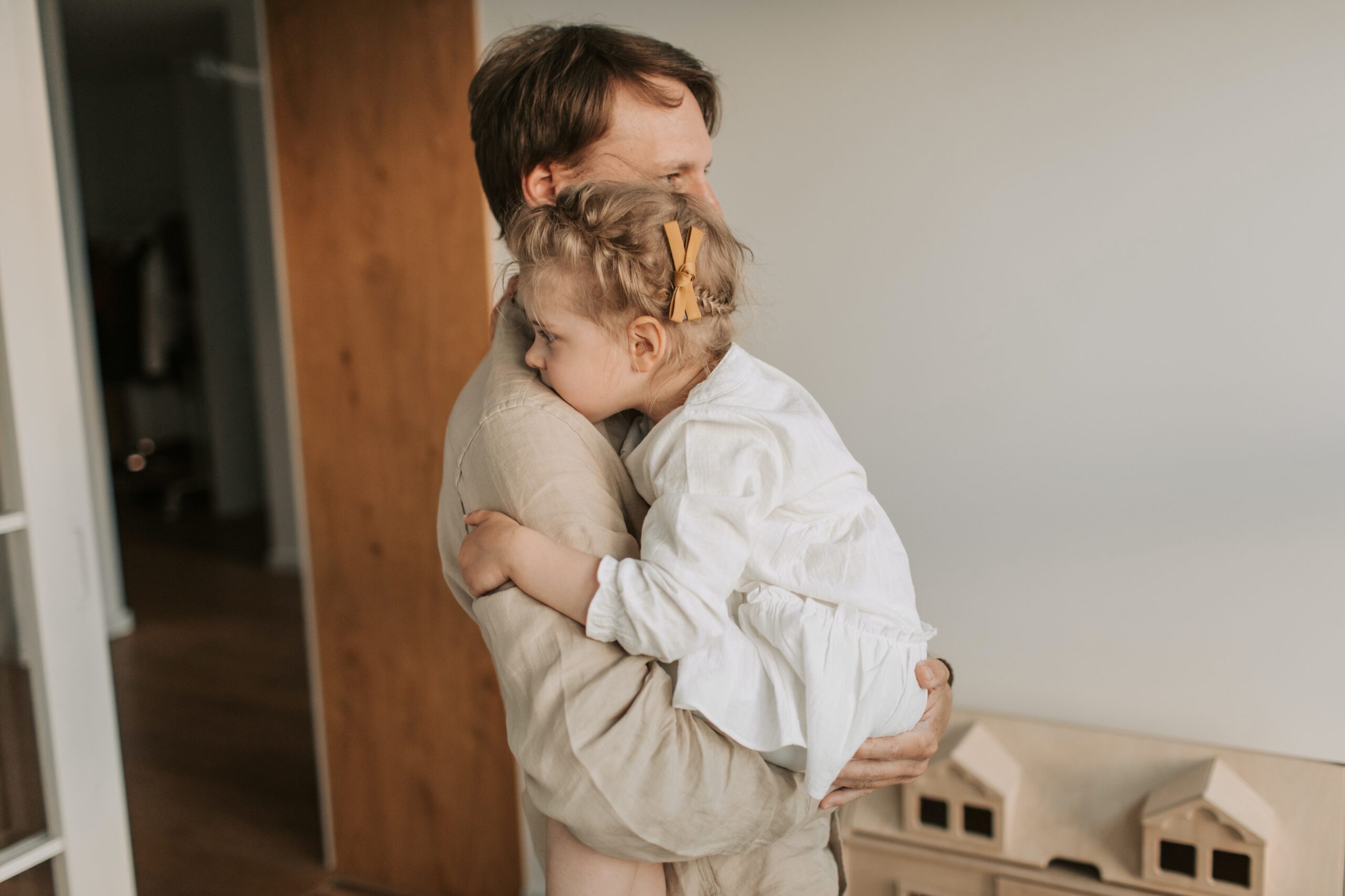É comum que adultos com autismo sem diagnósticos na infância, tenha sido consideradas somente crianças mais boazinhas e tímidas. Na foto pai com filha pequena no colo. 
