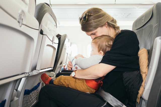 Foto Reprodução: Mãe viajando de avião com bebê de colo 